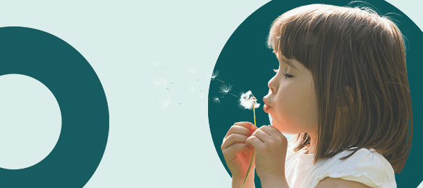 dziewczynka dmuchająca w kwiat