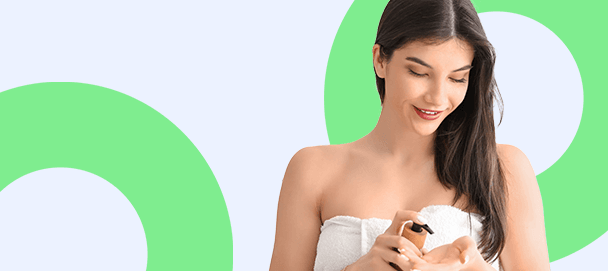 kobieta w ręczniku patrząca na kosmetyk